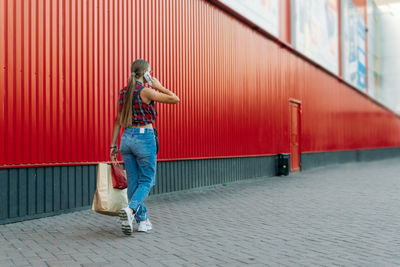 Full length of woman standing on footpath