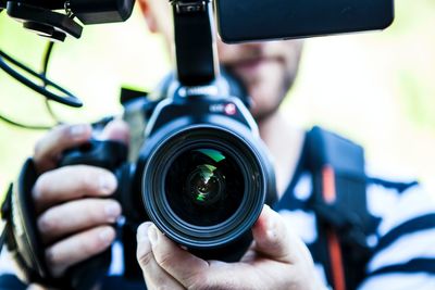 Close-up of man photographing with camera