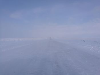 Snow covered landscape against sky