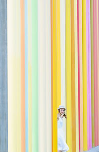 Side view of man standing against multi colored wall