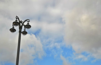 Low angle view of street light against cloudy sky