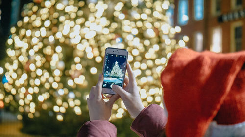 Midsection of person photographing with mobile phone