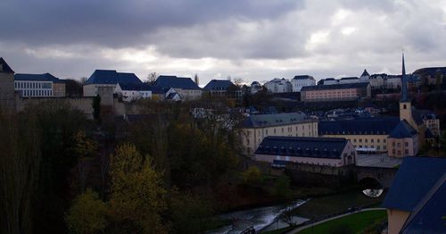 Buildings in town against cloudy sky