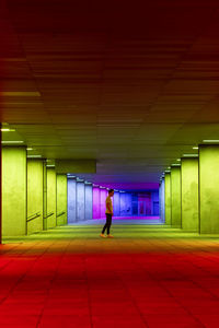 Rear view of woman walking in tunnel