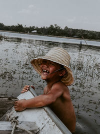 Portrait of shirtless man sitting in lake