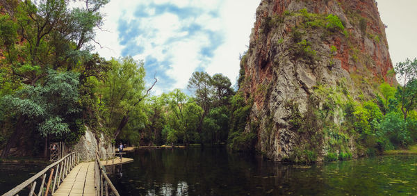 River amidst trees in forest against sky