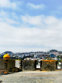 View of buildings in city against cloudy sky