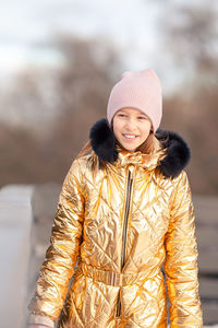 Portrait of young woman wearing warm clothing standing outdoors