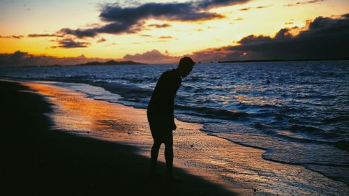 Silhouette person on beach during sunset