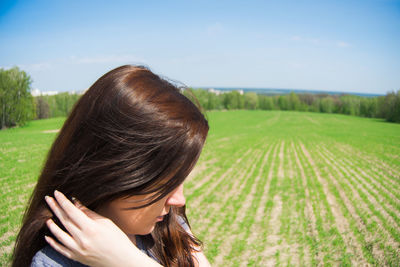 Close-up of woman on agricultural field against sky during sunny day