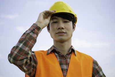 Portrait of young man standing against sky