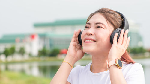 Portrait of smiling woman using mobile phone outdoors