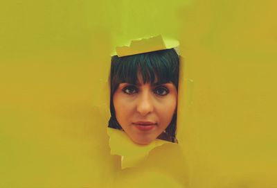 Portrait of woman against yellow wall