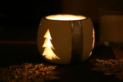 Close-up of lit candle in dark room