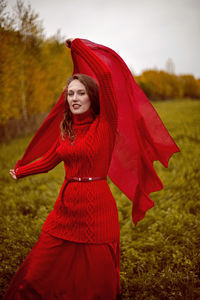Portrait of young woman standing on field