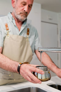 Midsection of man working in kitchen