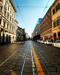 Cars on street in city against clear sky