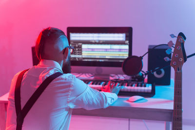 Rear view of man playing piano