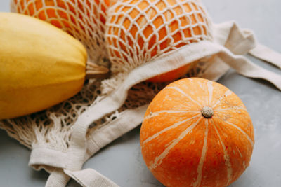 Mesh shopping bag with vegetables. autumn pumpkin harvest