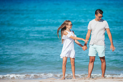 Rear view of couple standing at beach