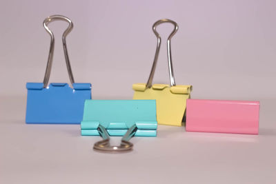 Close-up of colorful blinder clips on white background