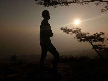 Silhouette man standing against sky during sunset