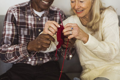 Elderly man and woman knitting together at retirement home