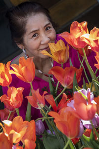 Close-up of woman with orange flowers