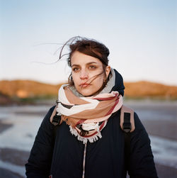 A woman stands on the seashore near the mountain