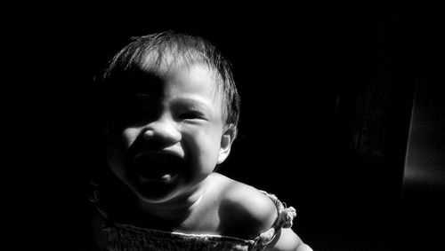 Portrait of cheerful baby girl in darkroom