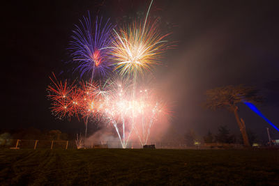 Low angle view of firework display at night