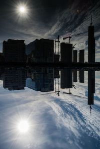 Reflection of sun in water against sky