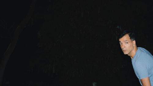 Portrait of shocked mid adult man at night