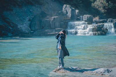 Rear view of woman standing at beach