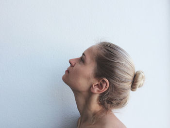 Close-up of young woman standing on white background