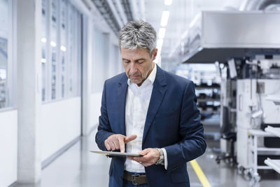 Mature businessman using tablet pc in industry