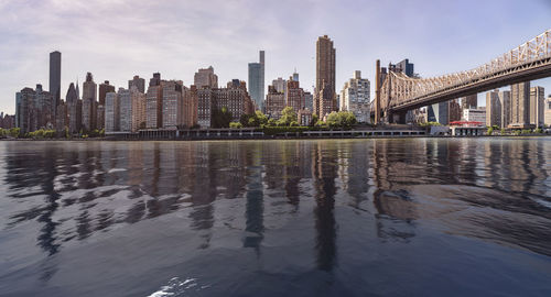 Reflection of buildings in river against sky