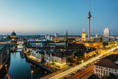 Illuminated buildings in city against sky