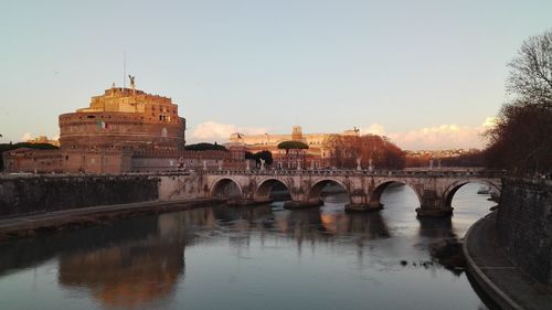 Arch bridge over river by hadrian tomb against sky