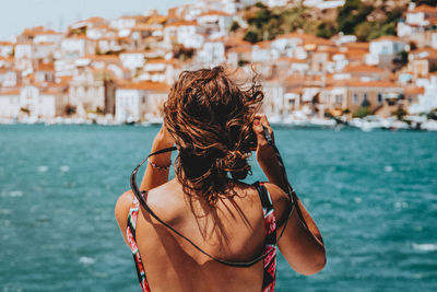 Rear view of woman standing against sea