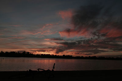 Scenic view of sea against cloudy sky at sunset