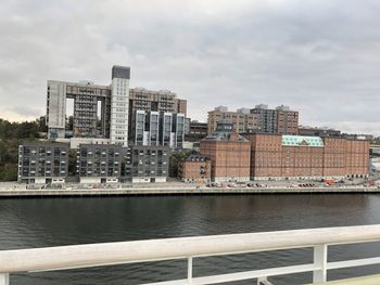 River by buildings in city against sky