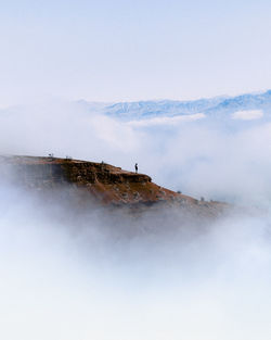 Distant view of people on boat against sky