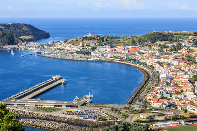 High angle view of city by sea against sky