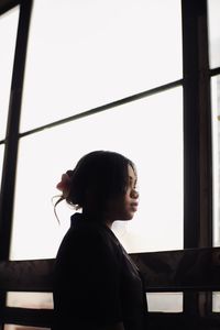 Side view of boy looking through window