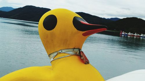 Close-up of yellow flag on water against sky