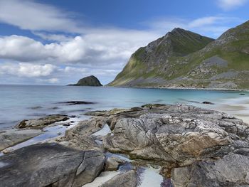 Scenic view of beach, rocks, and sea against sky