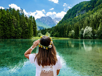 Rear view of woman in lake against mountains