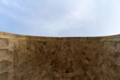 Low angle view of stone wall against sky