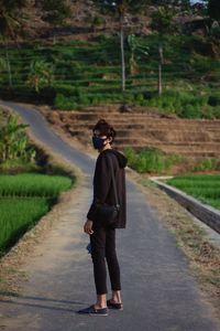 Full length rear view of man walking on footpath